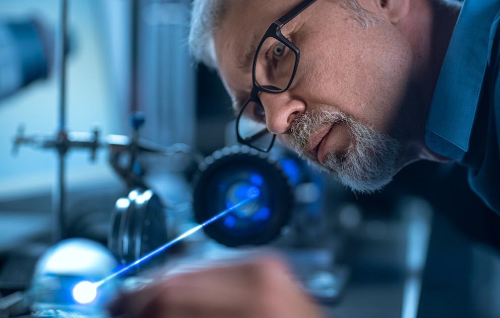 Scientist looking down laser